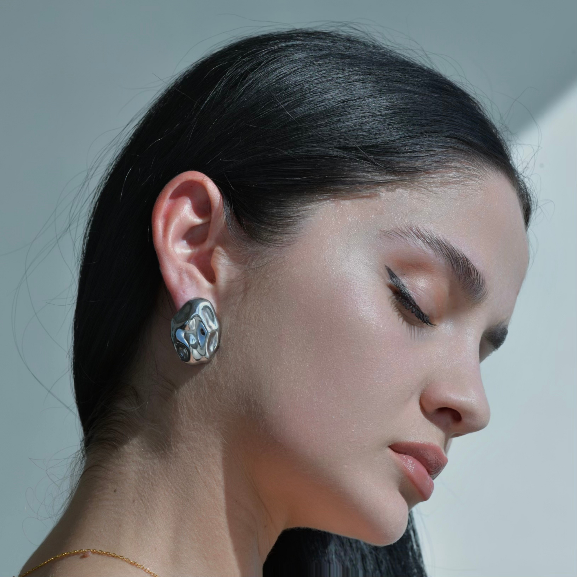 Silver Oval Earring with an irregualr surface resembling an hammered metal with the shape of an oval rock. Silver Plated. Pebble Silver Earrings