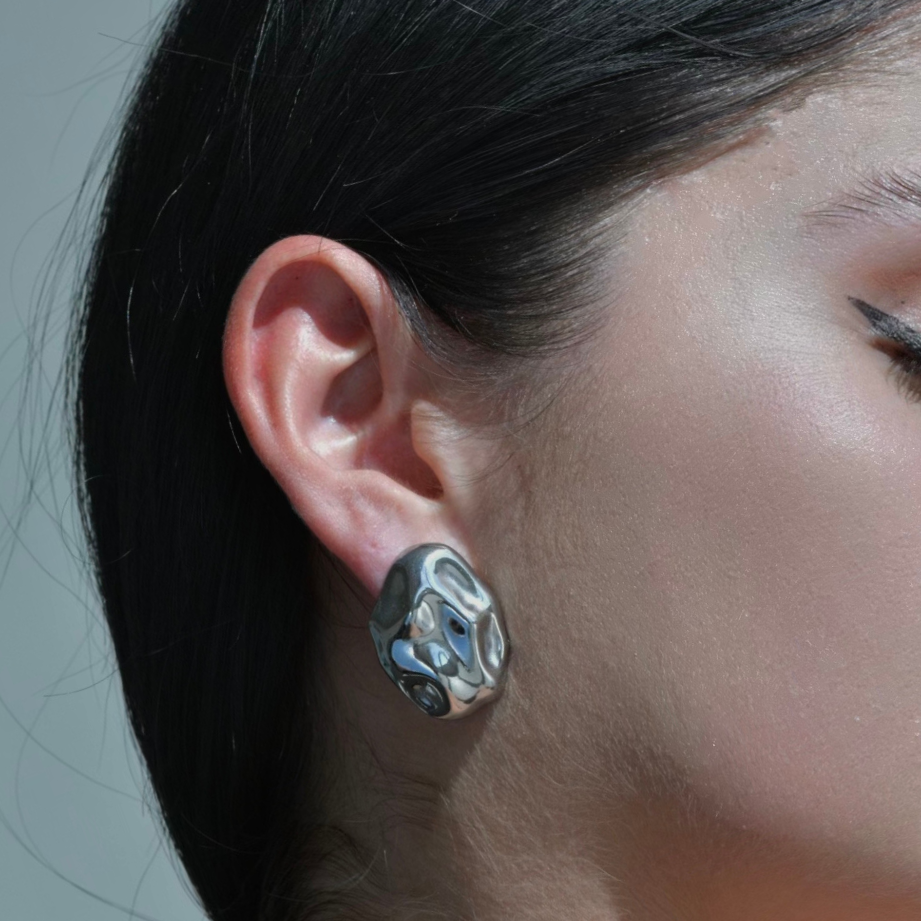 Silver Oval Earring with an irregualr surface resembling an hammered metal with the shape of an oval rock. Silver Plated. Pebble Silver Earrings