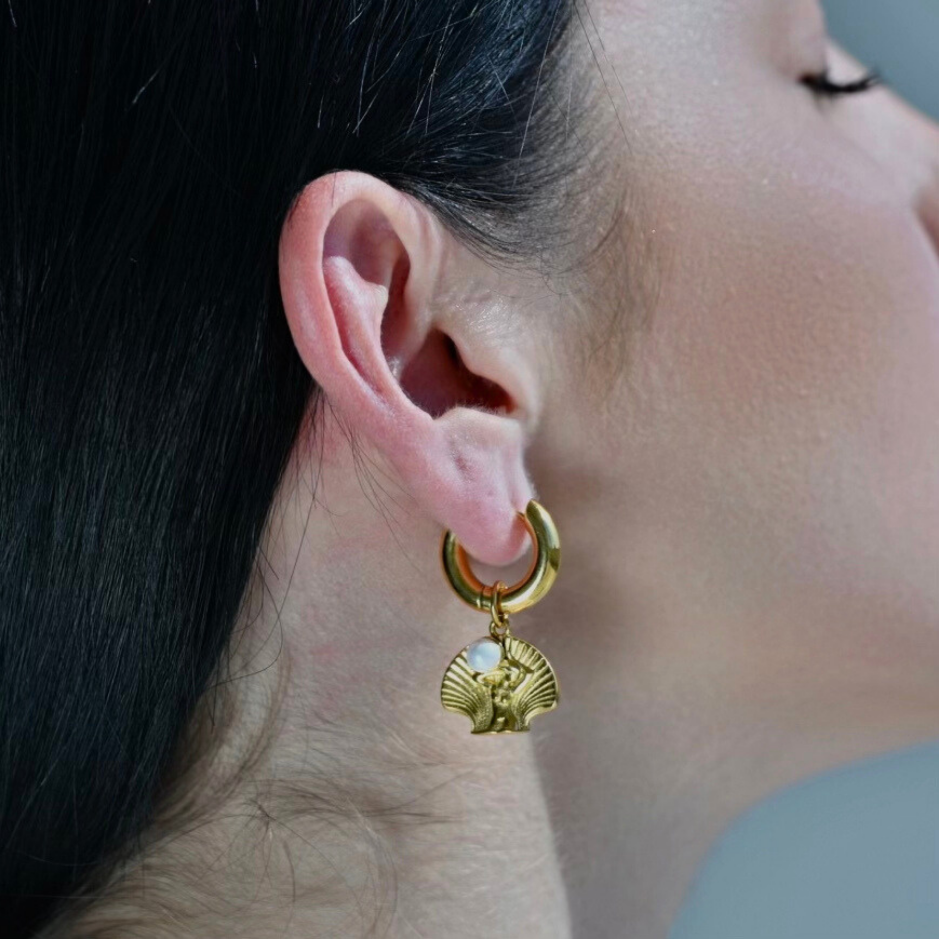 Gold Earrings with Woman body in a shell with a white pearl on her hands pendant. the pendant is droped in gold hoop. the pendant is detachable from the golden hoop.