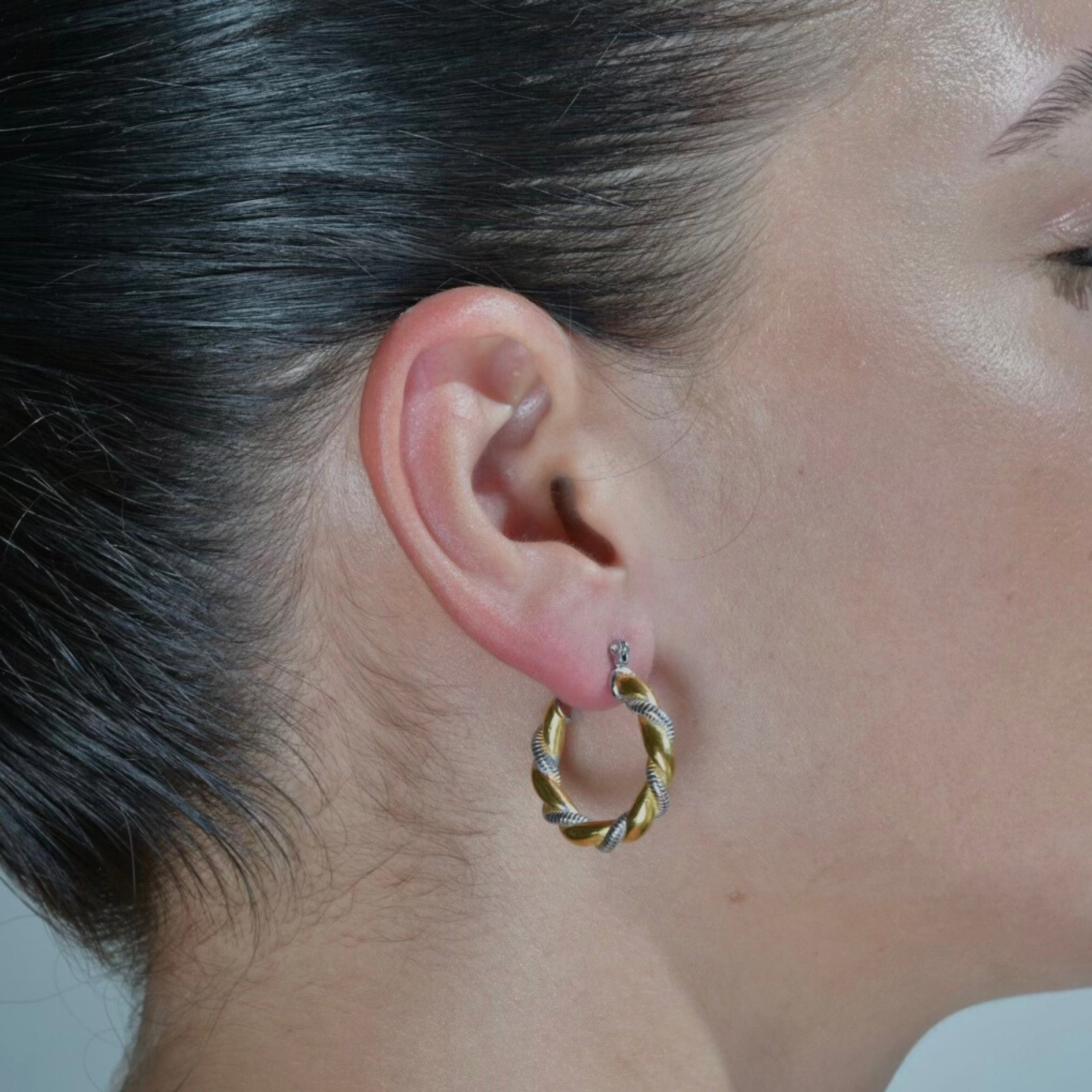  Model wearing Gold hoop earrings with twisted silver elegant nail twisted around it. A mixed metal hoop.