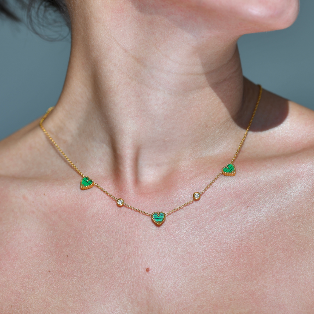 AMORE Malachite Heart Gold Necklace. Three green malachite stones heart shape necklace. Two zircons attached at the chain separating the three hearts.