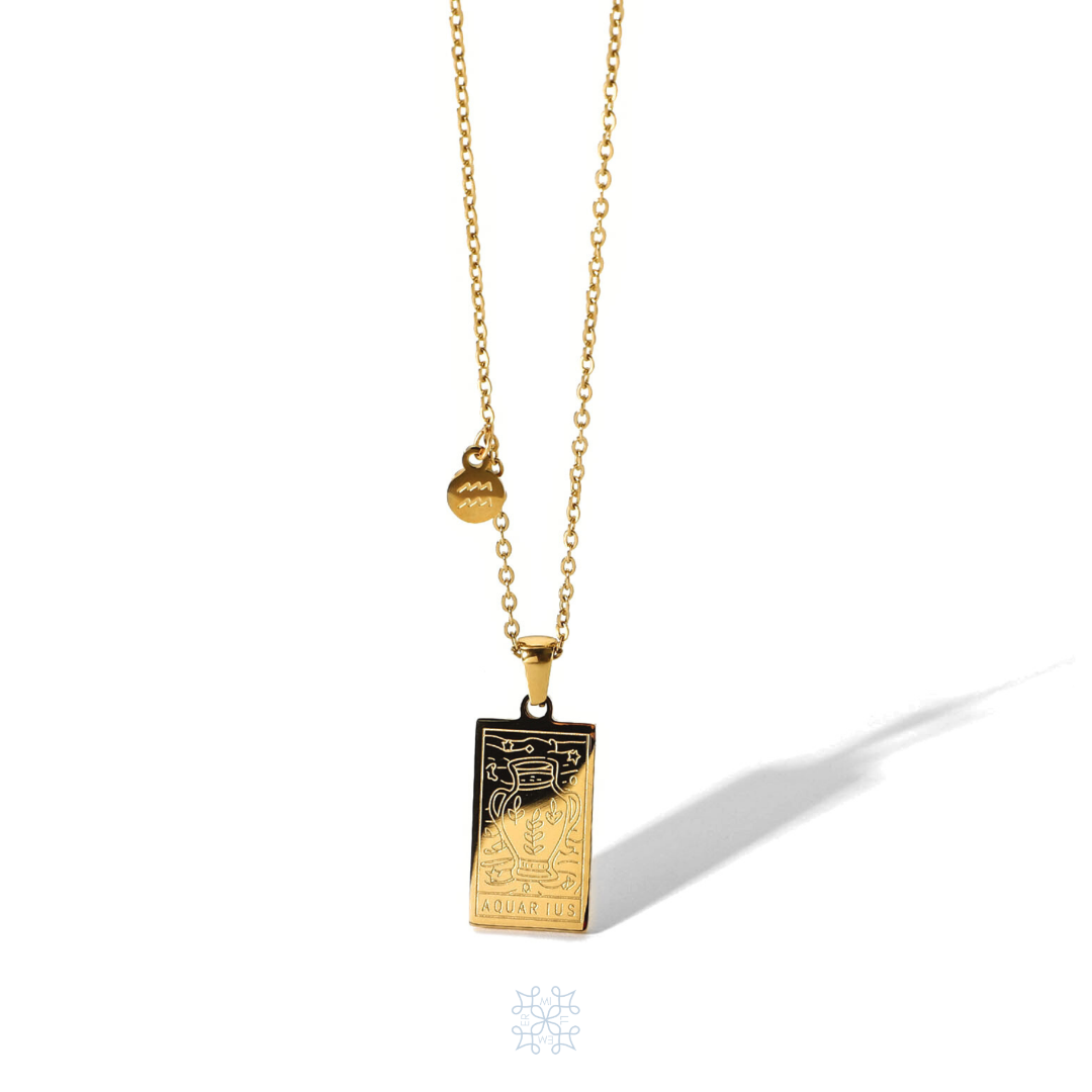AQUARIUS Zodiac Pendant Gold Necklace. Rectangular shape pendant with an aquarius symbol vase engraved on top of it, the aquarius word written on the bottom. one side of the gold chain has a small round aquarius symbol attached, The pendnat is droped in a gold chain.