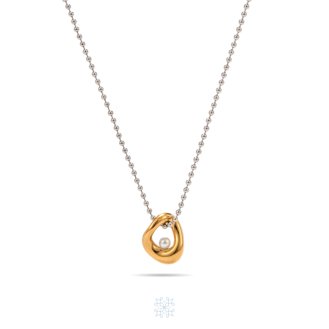 Silver dainty chain with a gold irregular oval shape pendant. A withe pearl attached in the middle of the pendant. Arctic pearl pendant gold silver necklace