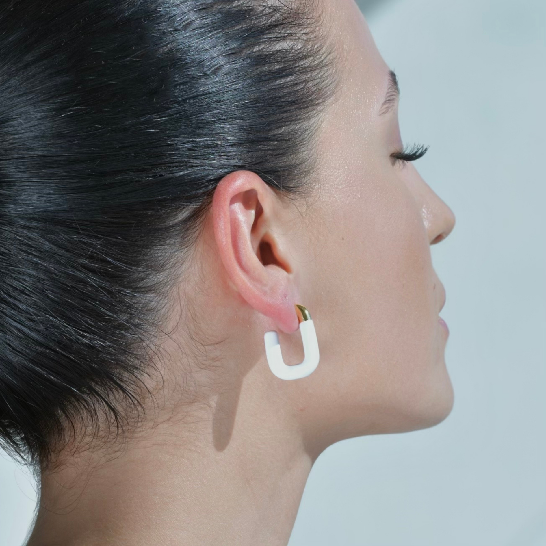 Gold Hoop Earrings Shaped in the form of letter U, more than half painted in white Enamel. Model wearing the earrings