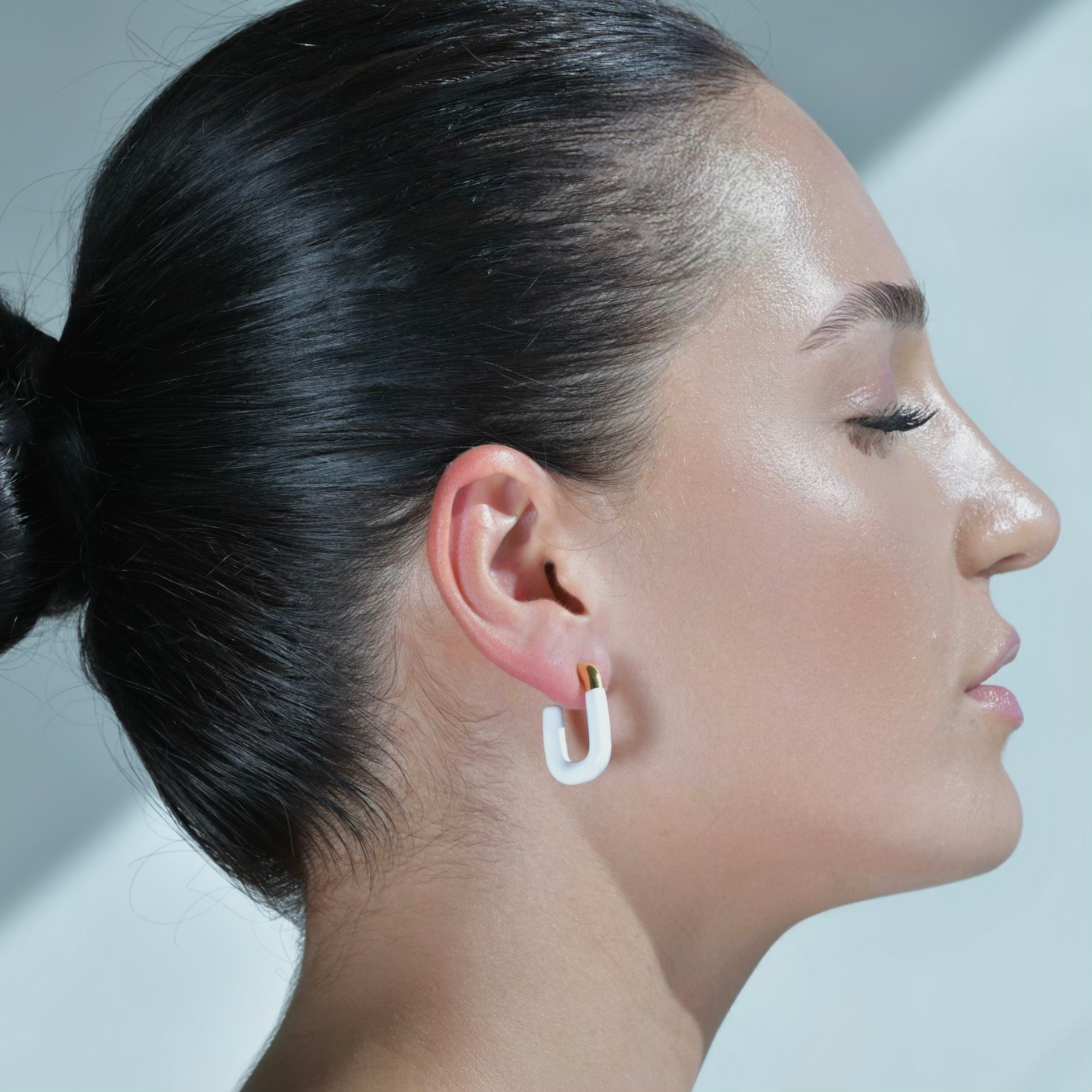 Gold Hoop Earrings Shaped in the form of letter U, more than half painted in white Enamel. Model wearing the earrings