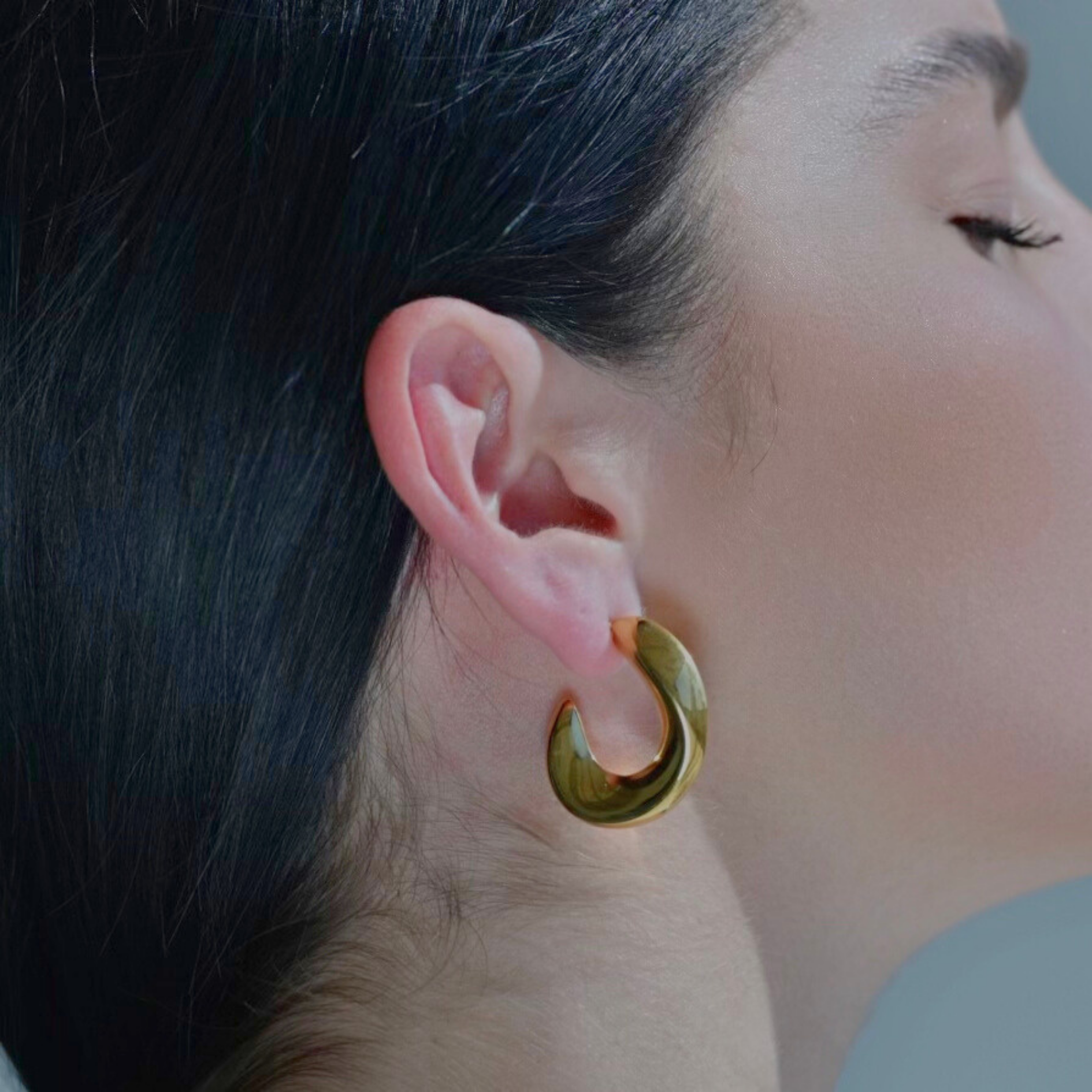 Gold irregular moon shaped hoop earrings.