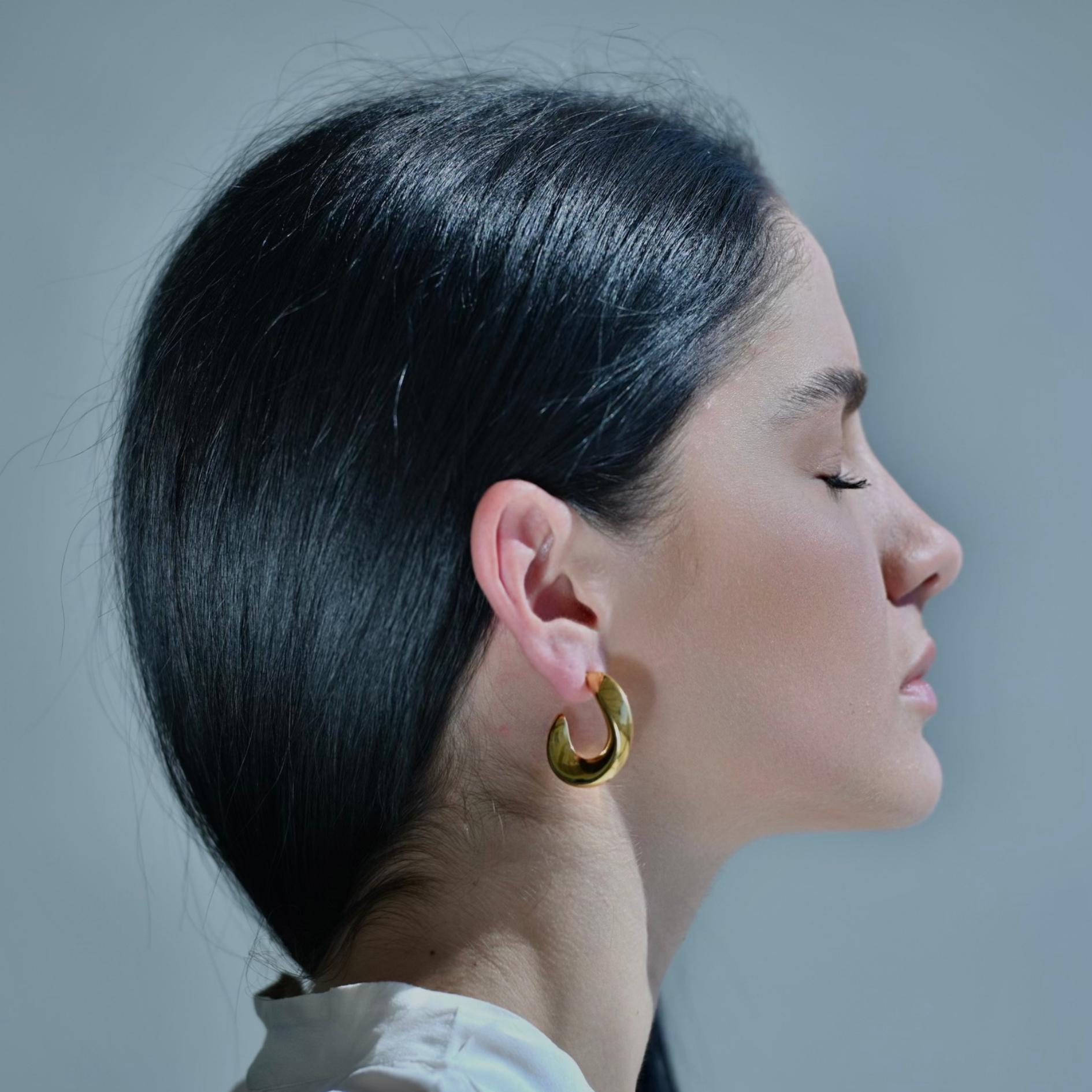 Gold irregular moon shaped hoop earrings.