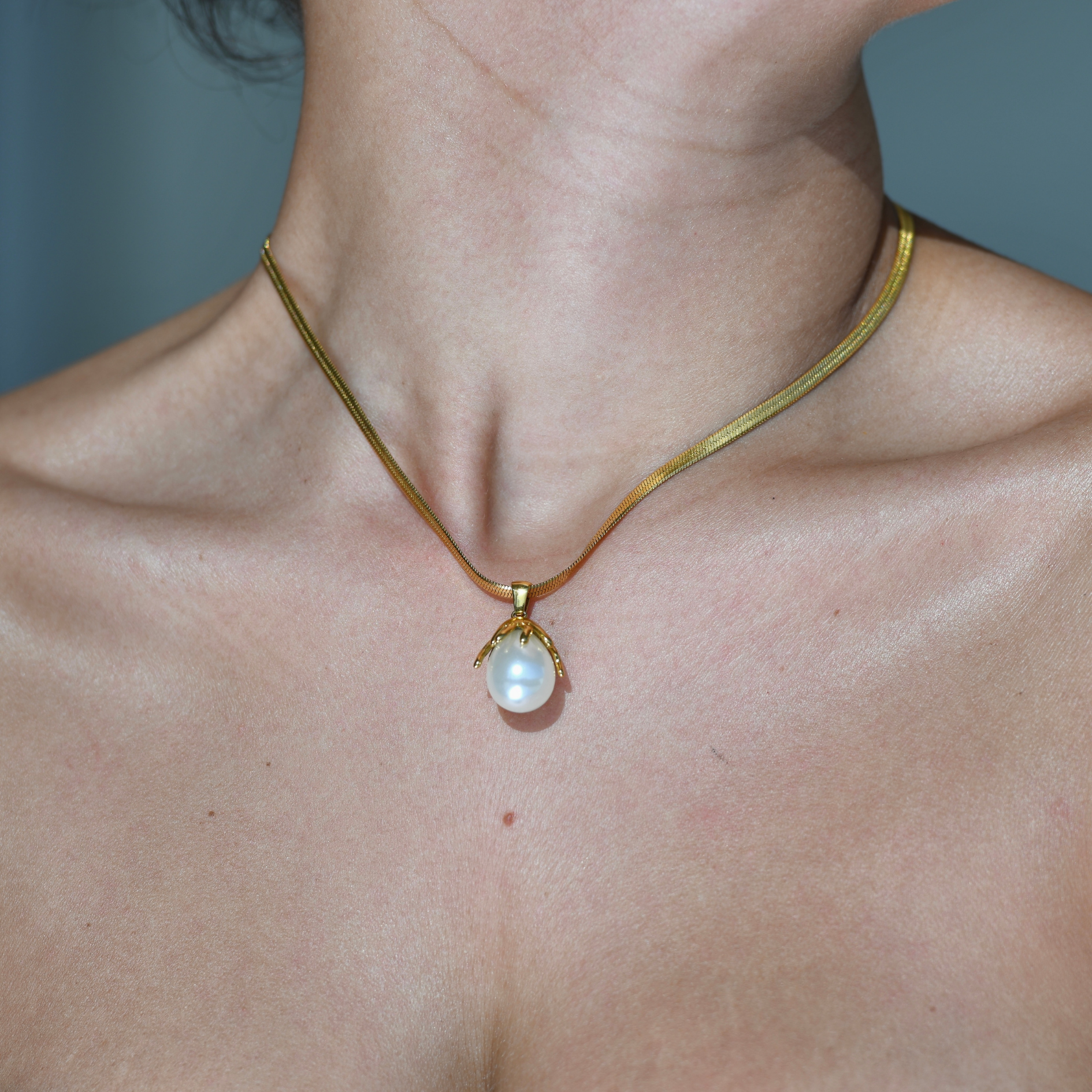 CORAL Pearl Pendant Gold Necklace - Herringbone gold chain with pearl pendant. The pearl is attched in the inside of a gold coral or flower shape metal pendant.
