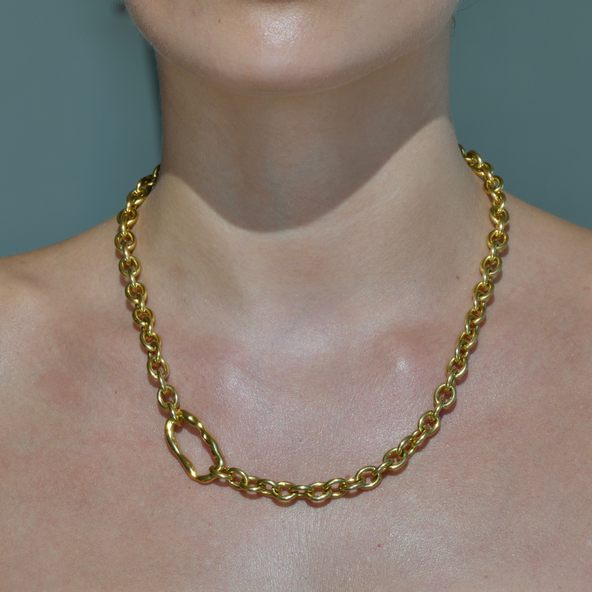 Bold Gold Chain with an irregular horizontal oval charm in the side of the chain. DUNE Gold Chain Necklace