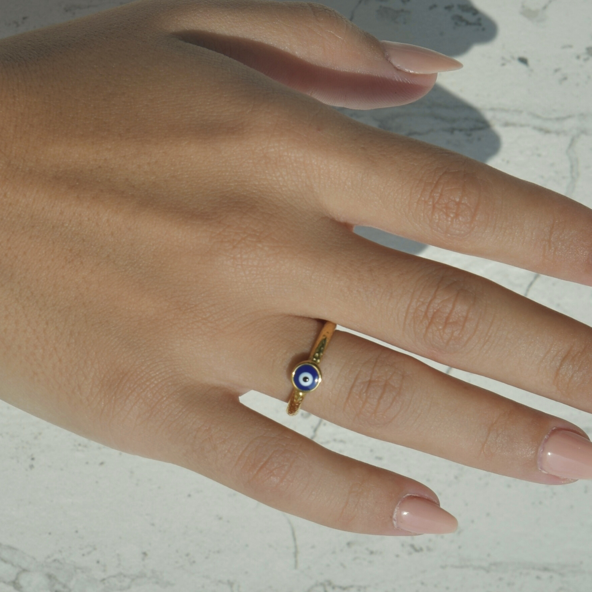  gold ring with irregular shape texture. Evil eye painted symbol in the middle.