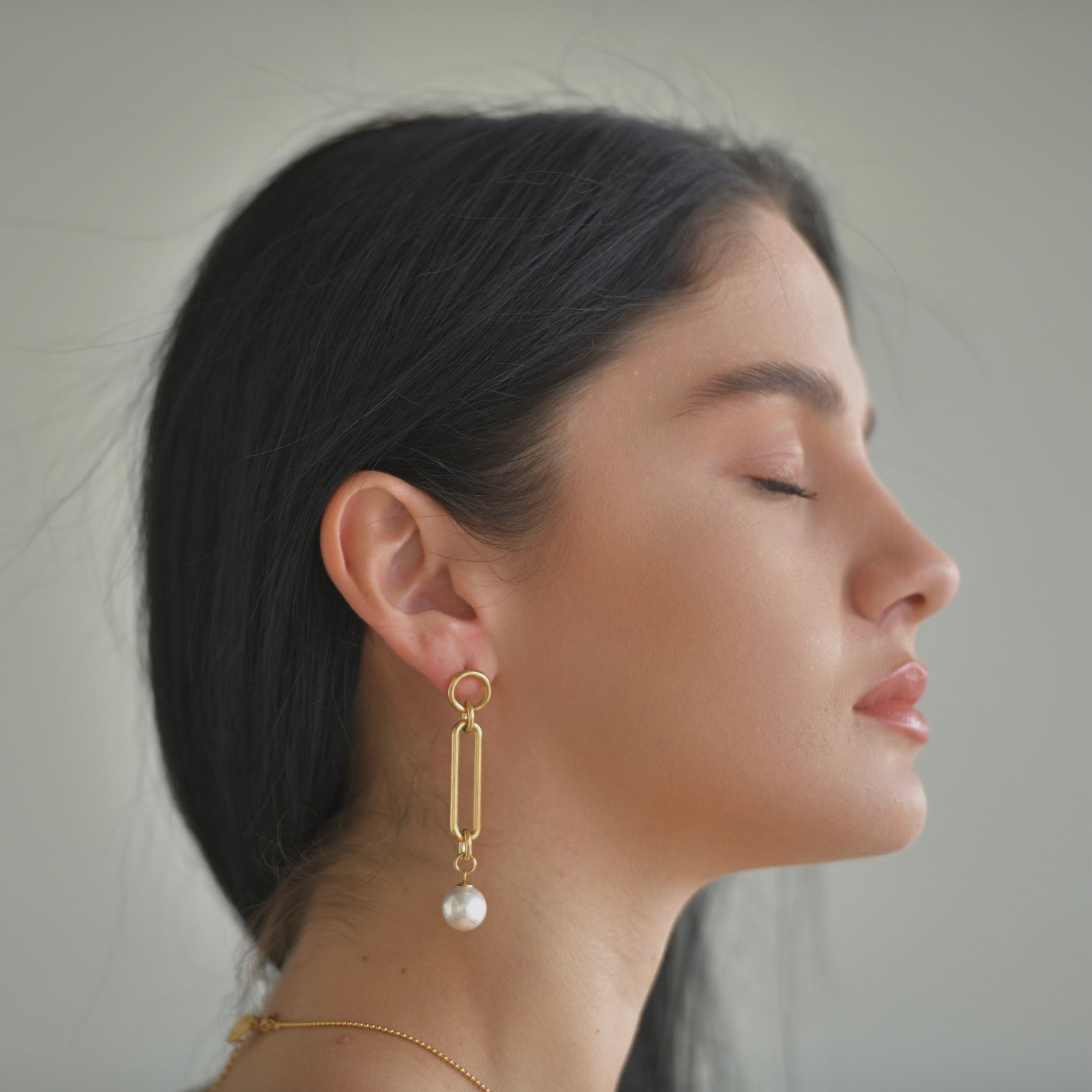 Gold plated earrings with a top small round hoop, a retacngle oval shape droping in the middle and a pearl droping at the bottom.