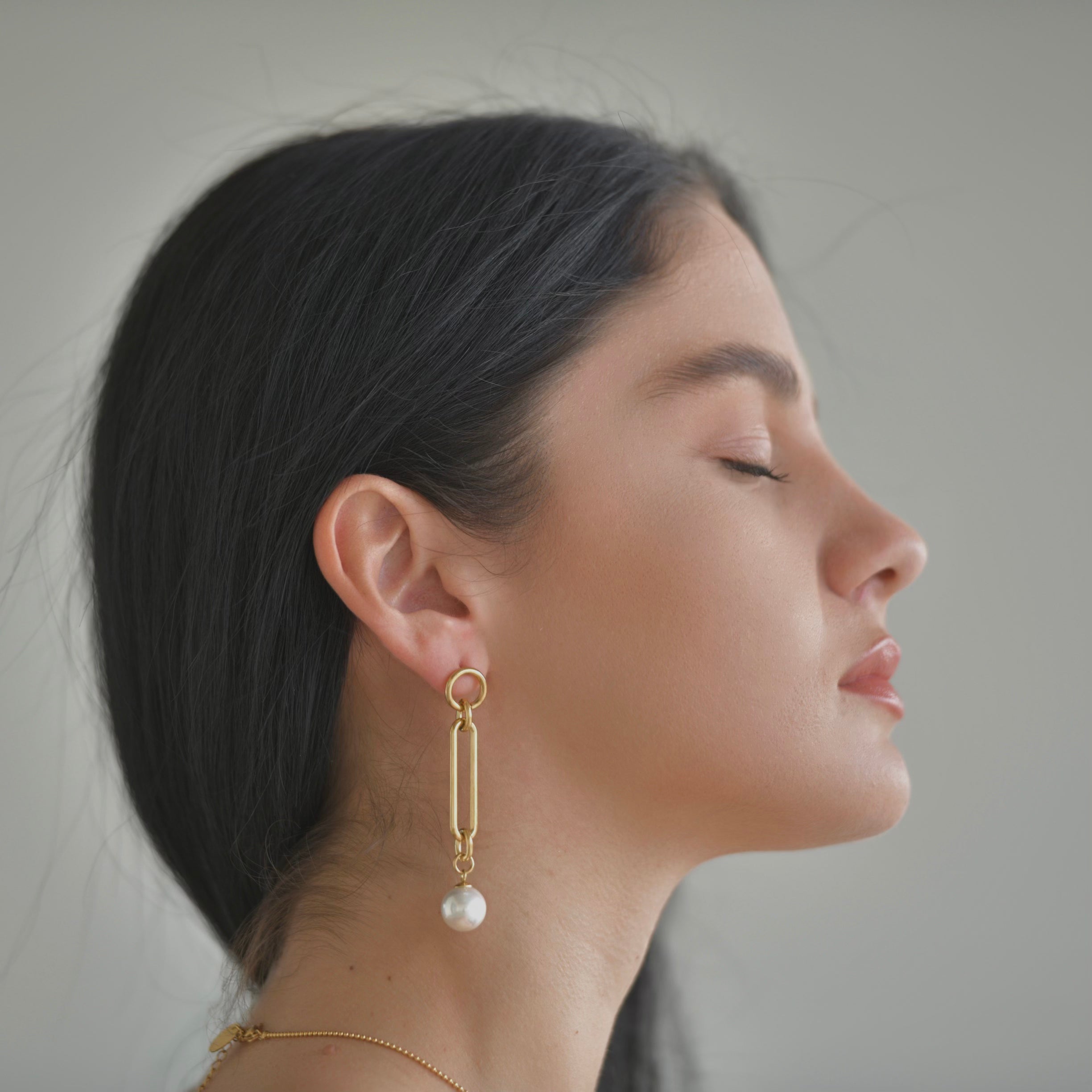 Gold plated earrings with a top small round hoop, a retacngle oval shape droping in the middle and a pearl droping at the bottom.
