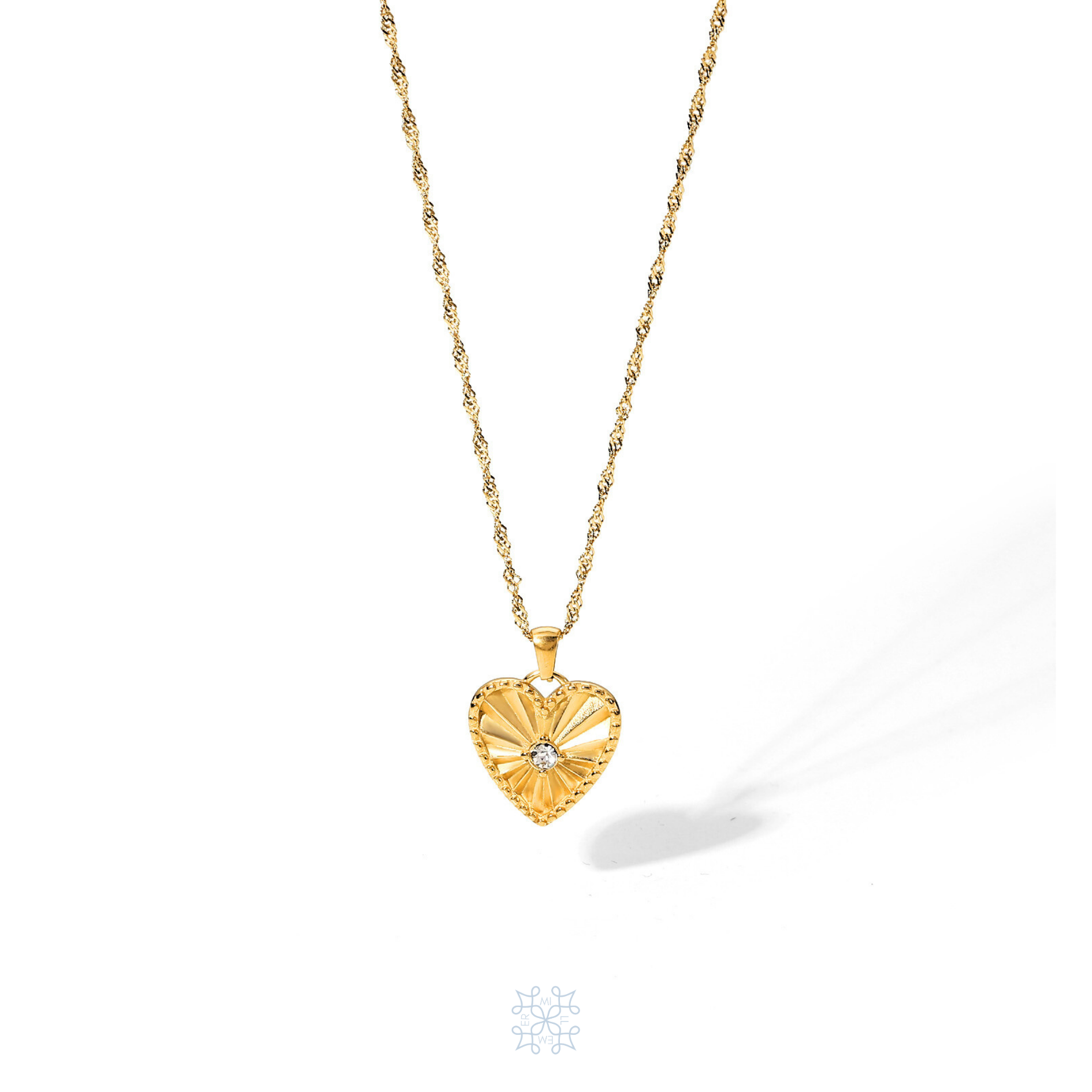 Gold plated chain necklace with a heart pendant droping on the chain. A zircon stone in the middle of the heart. The heart has engraved rays pattern starting from the middle opening the borders of the gold heart. Heart Pendant gold necklace.