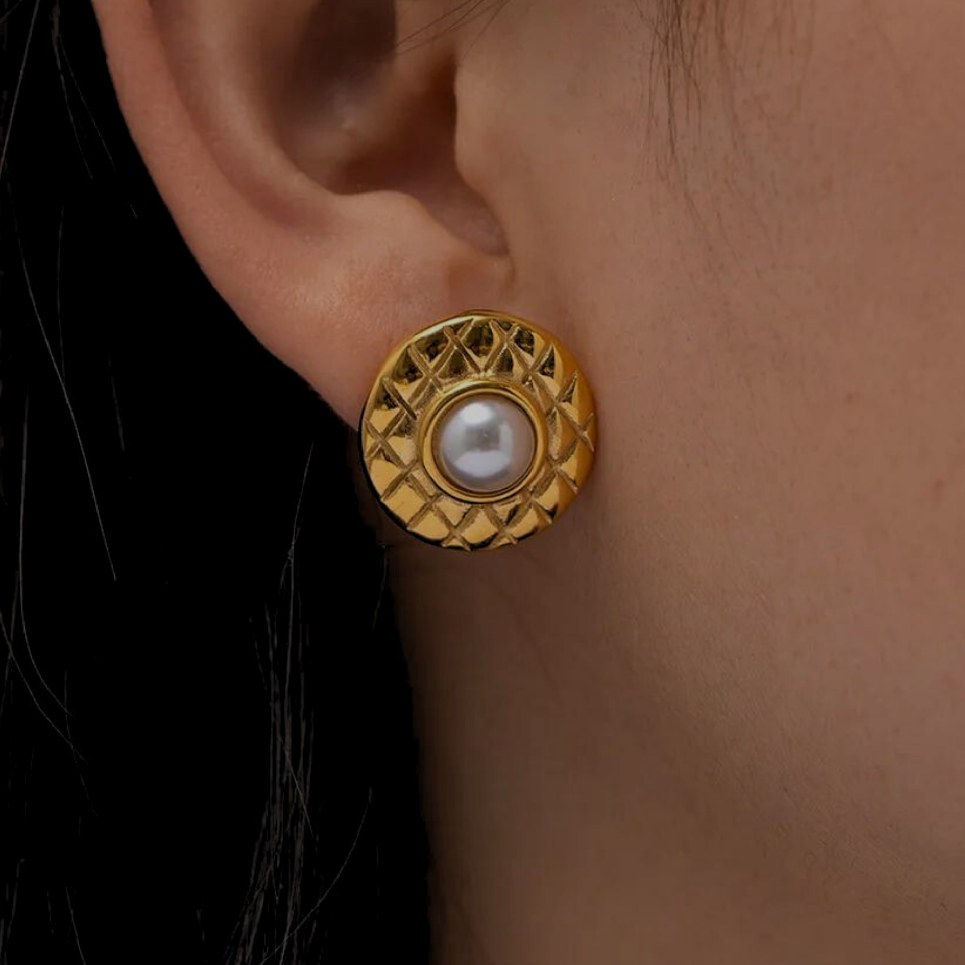 Square Stud earrrings with a white pearl in the middle. the gold corcle part is like a disc engraved in rhombus shapes.