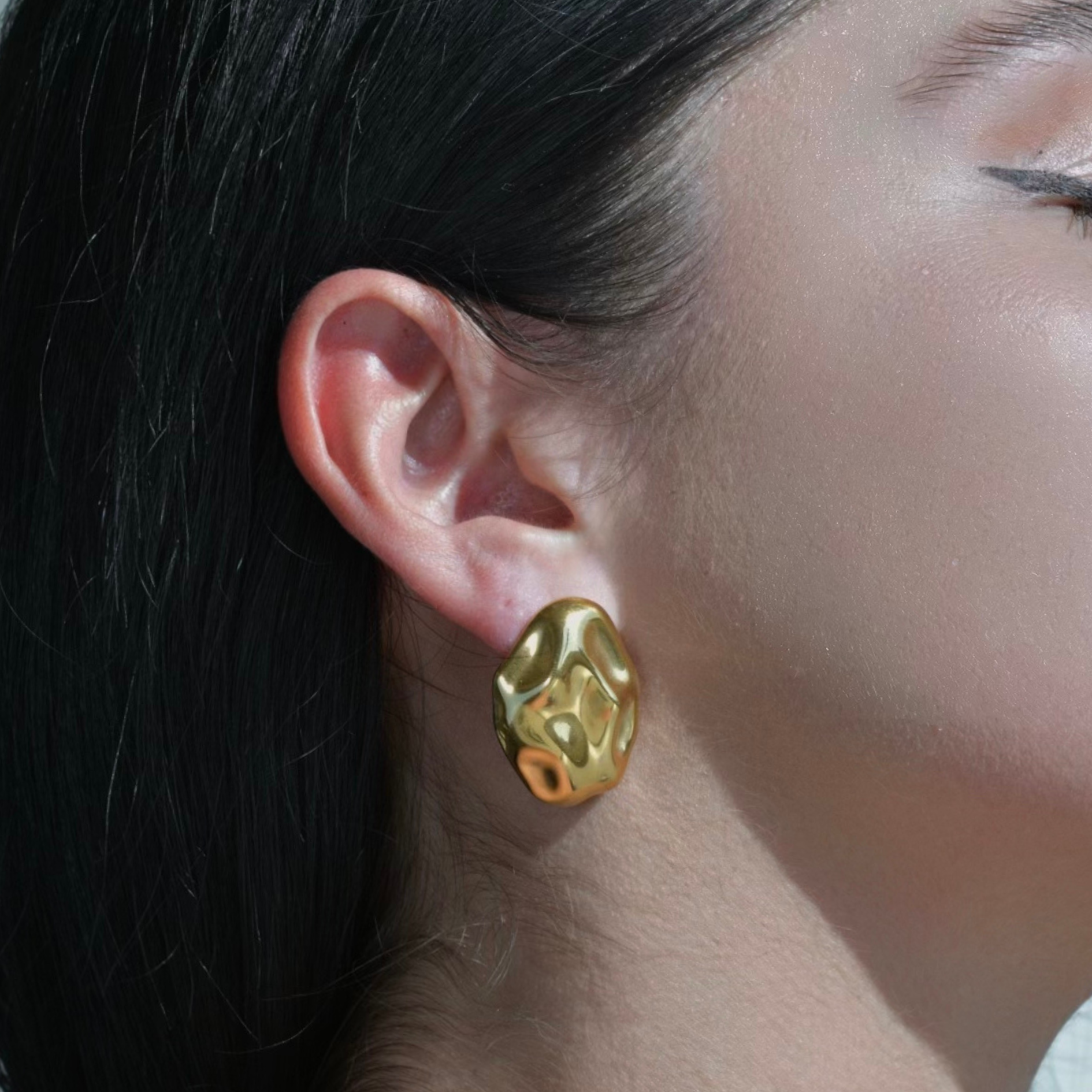 Gold chunky oval earrings ressembling an hammered surface of a rock. Pebble Gold Earrings