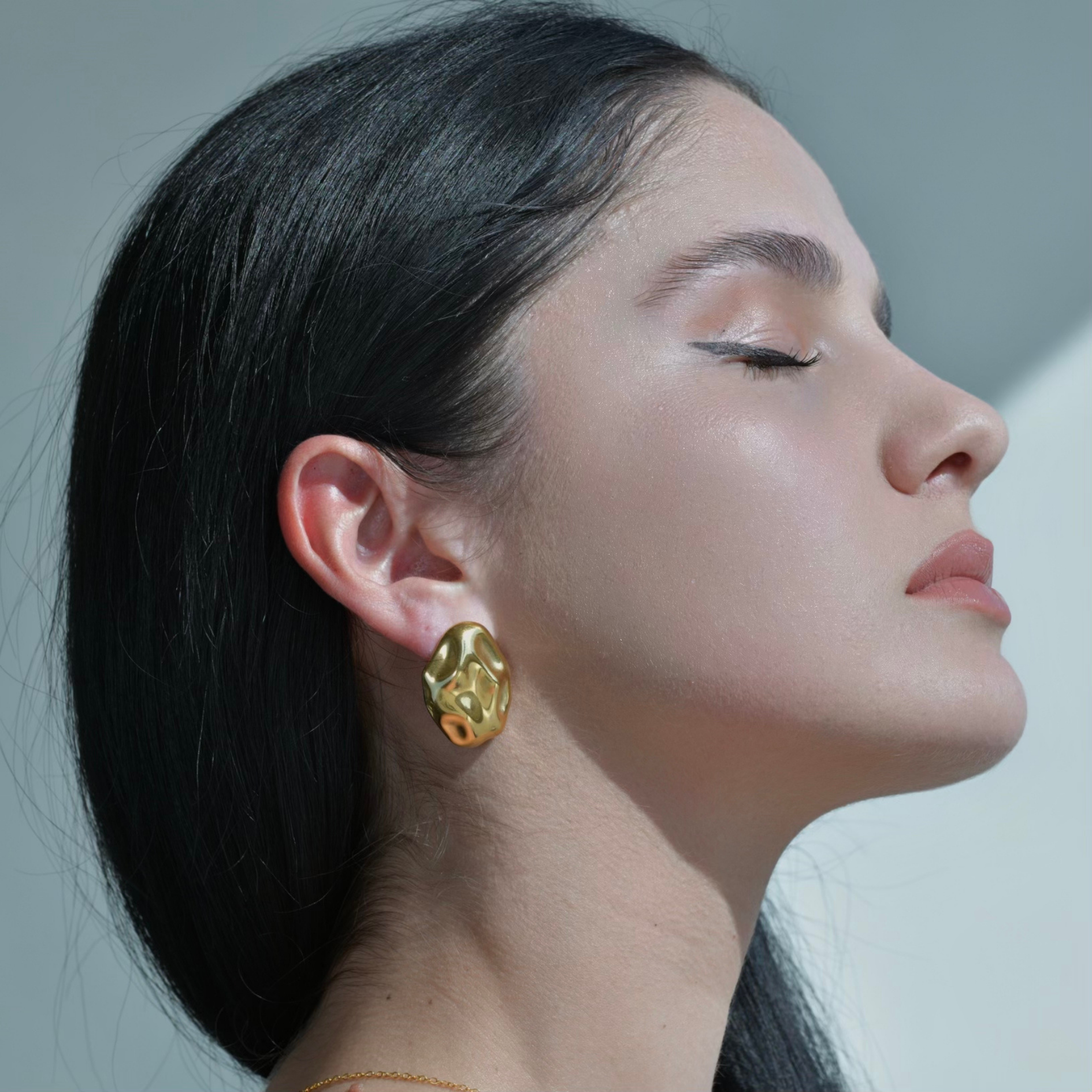 Gold chunky oval earrings ressembling an hammered surface of a rock. Pebble Gold Earrings