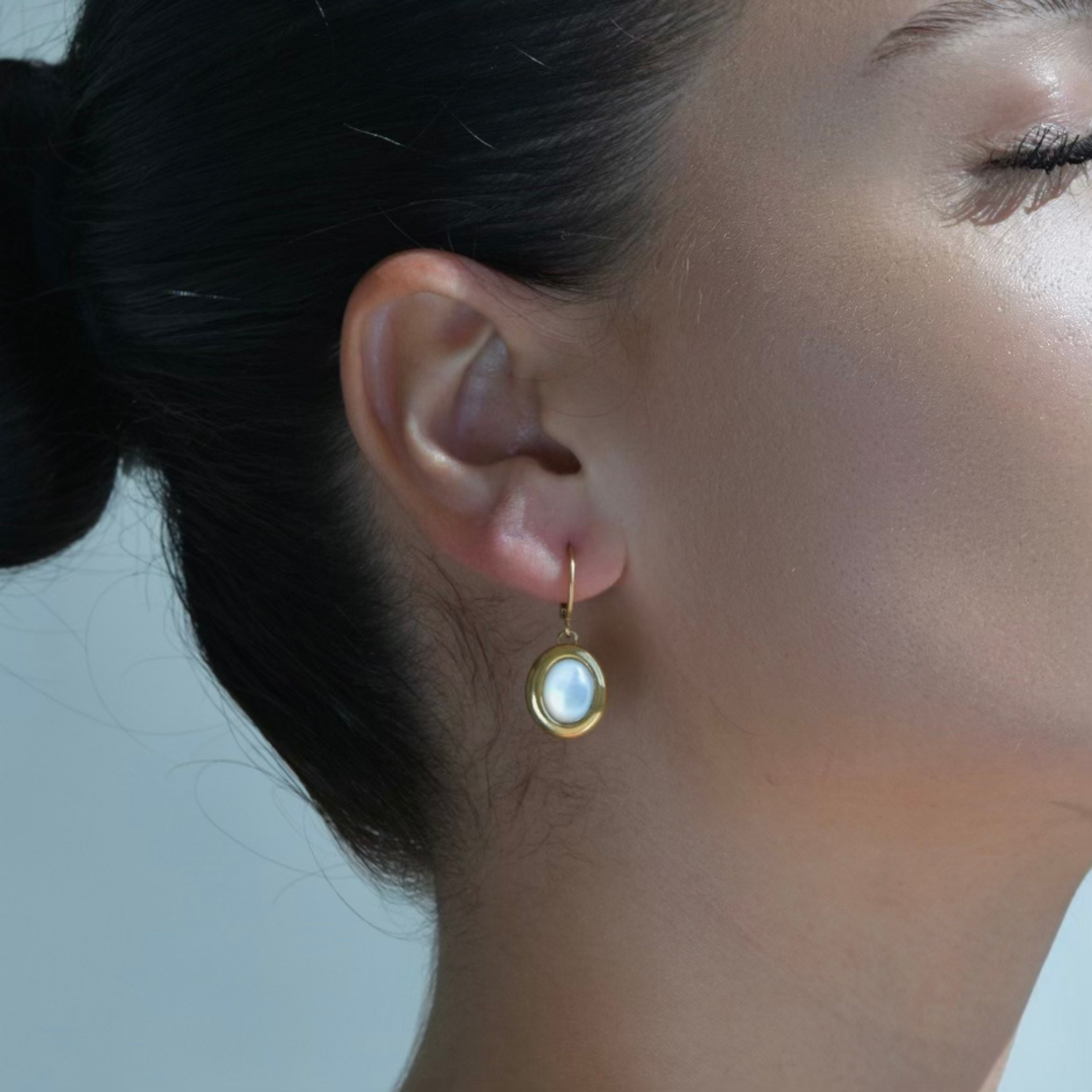 Gold hoop earrings with oval mother pearl drop.
