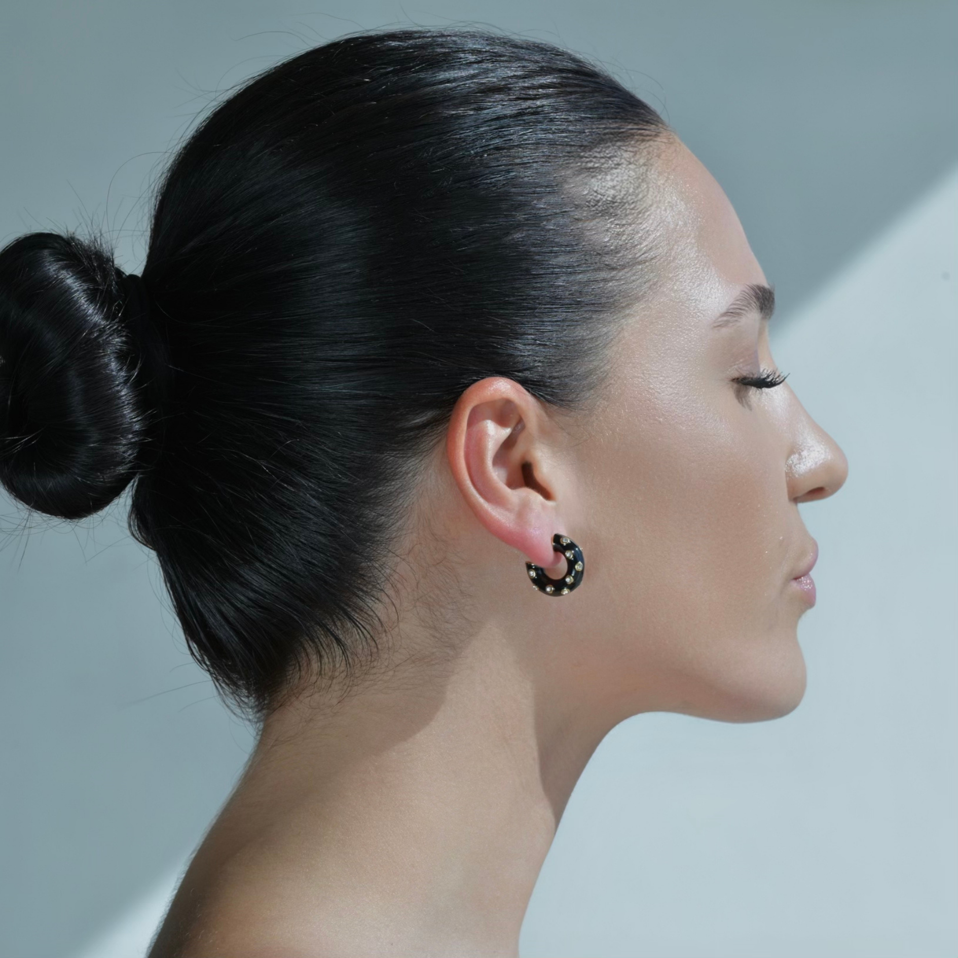woman wearing Gold plated Hoop Earrings painted with black enamel and adorned with zircons.
