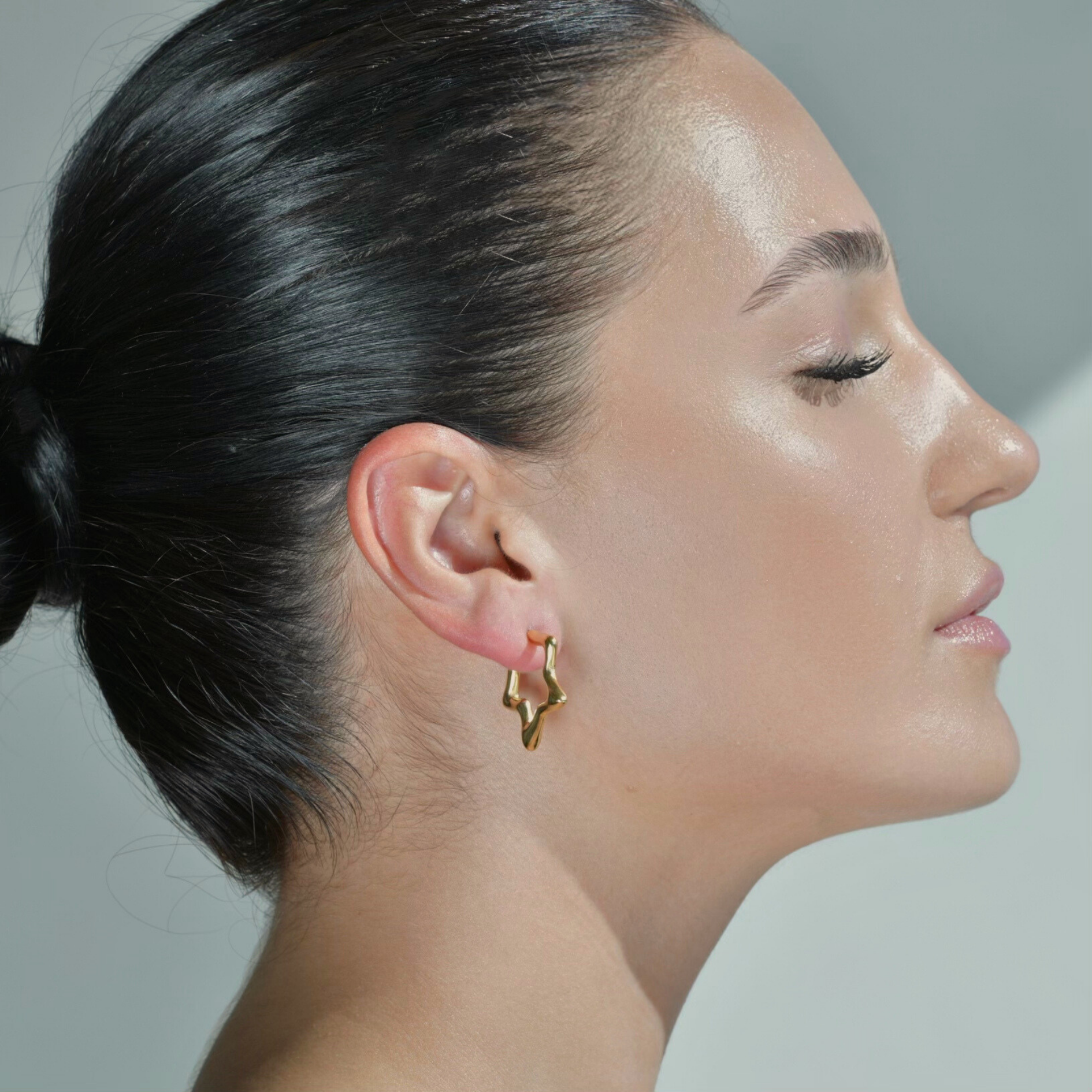 Women wearing the Star shaped gold hoop earrings. Irregular star shape pair of earrings.
