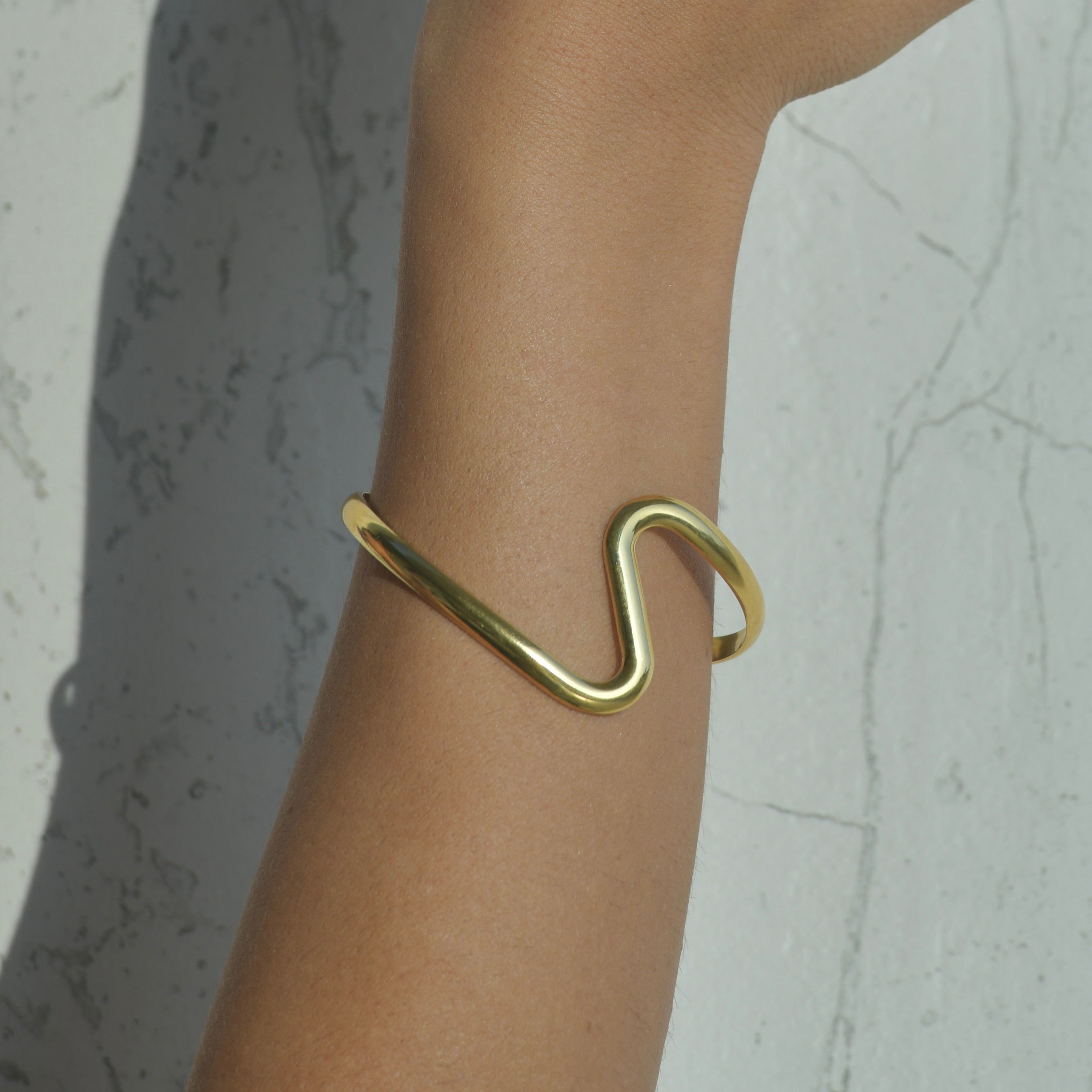 Tidal Cuff Gold Bracelet. Elegant cuff bracelet with a wave shape in the middle of the bracelet.