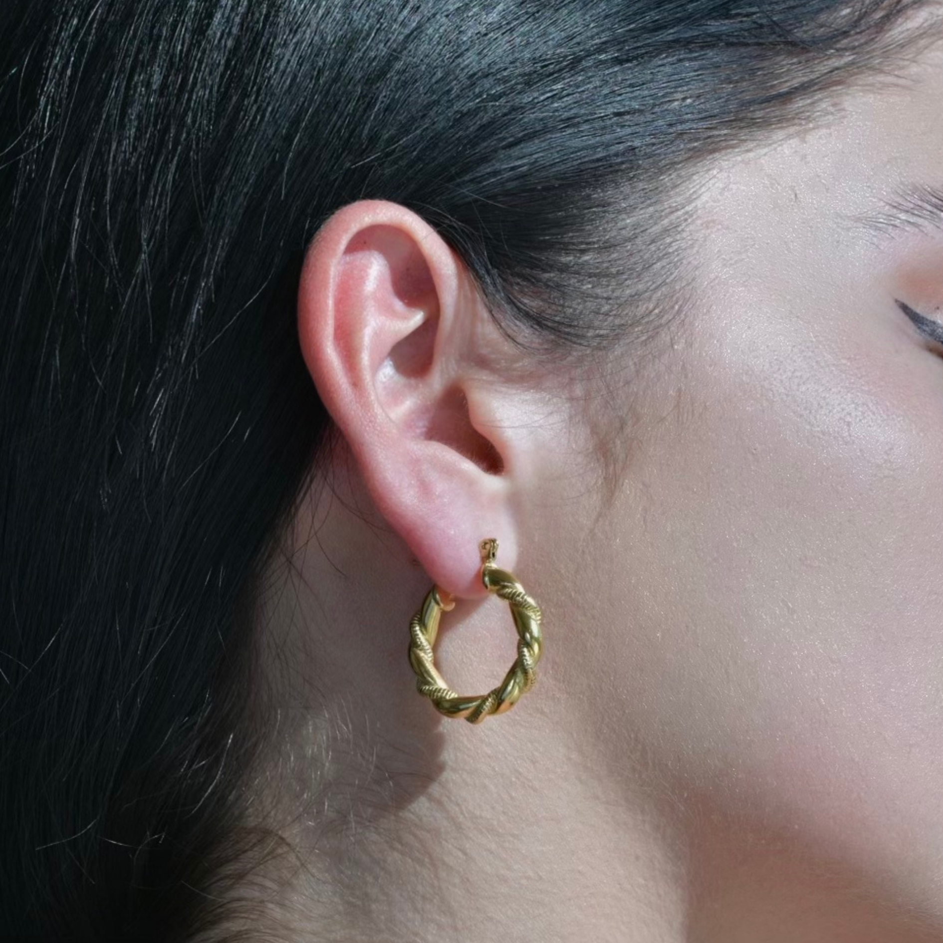 Gold Hoop Earrings with a twisted elegant nail around the hoop surface. Model Ear Photo.