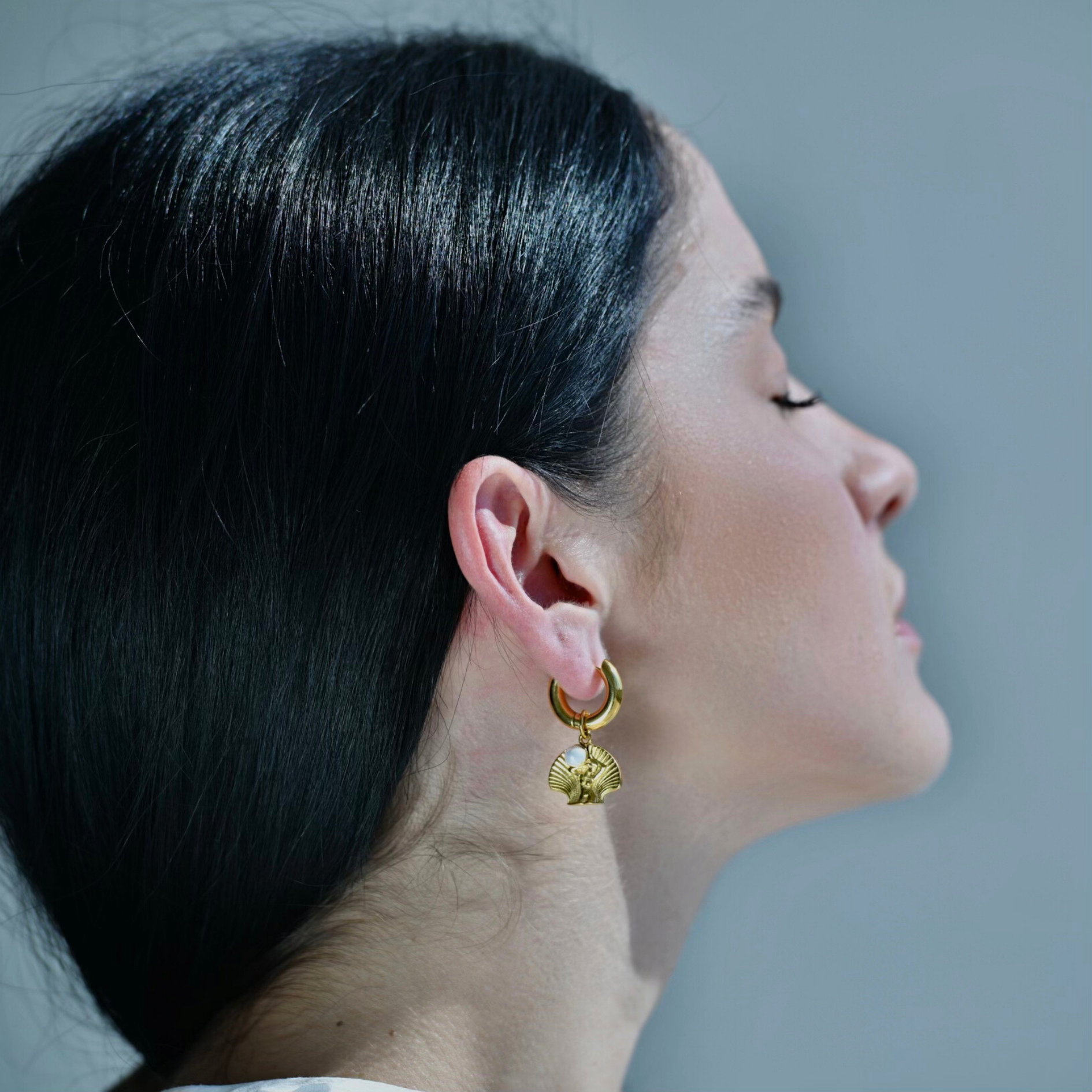 Gold Earrings with Woman body in a shell with a white pearl on her hands pendant. the pendant is droped in gold hoop. the pendant is detachable from the golden hoop.
