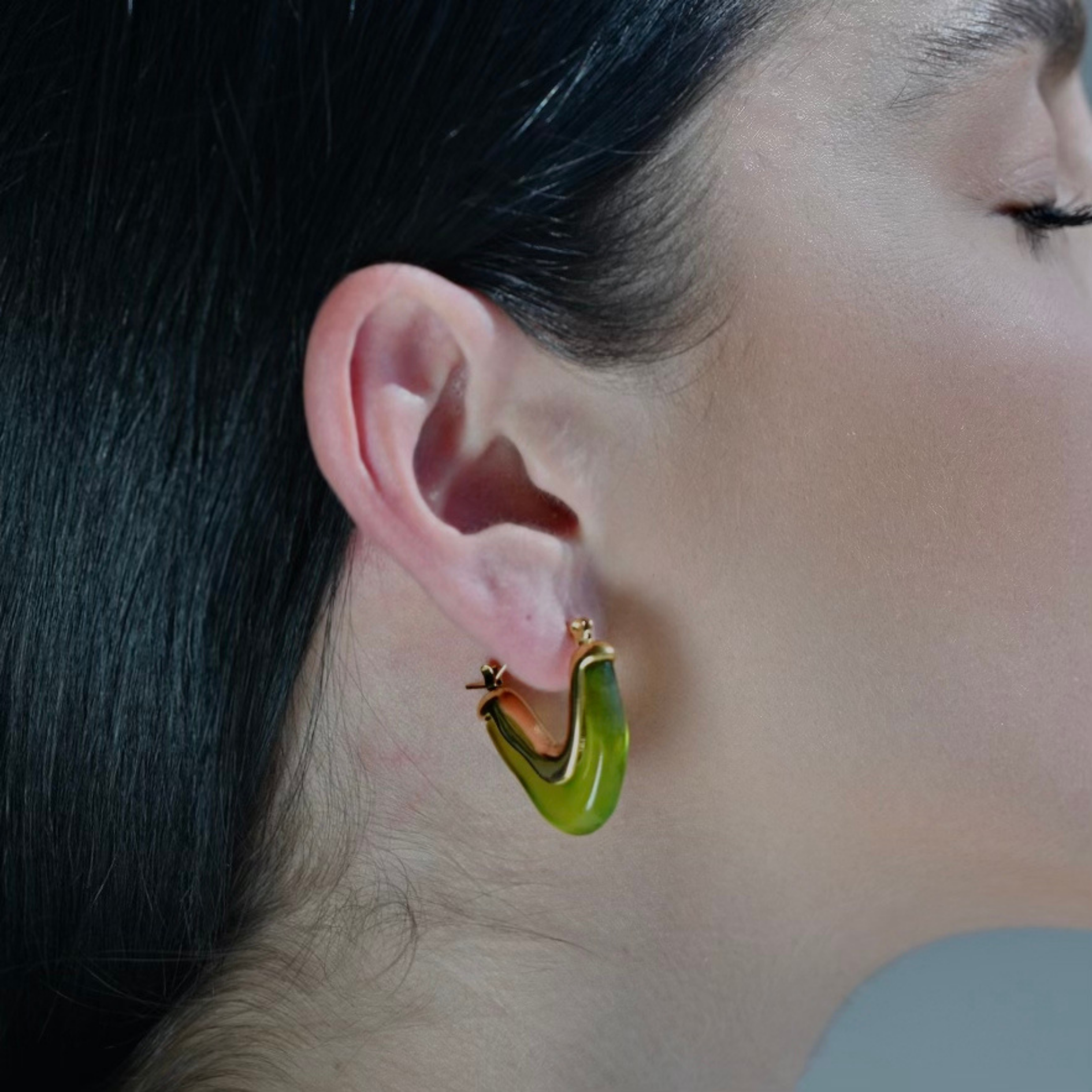Model wearing a V shape Gold Plated Hoop Earrings made with Green Acrylic. Waterproof Earrings.