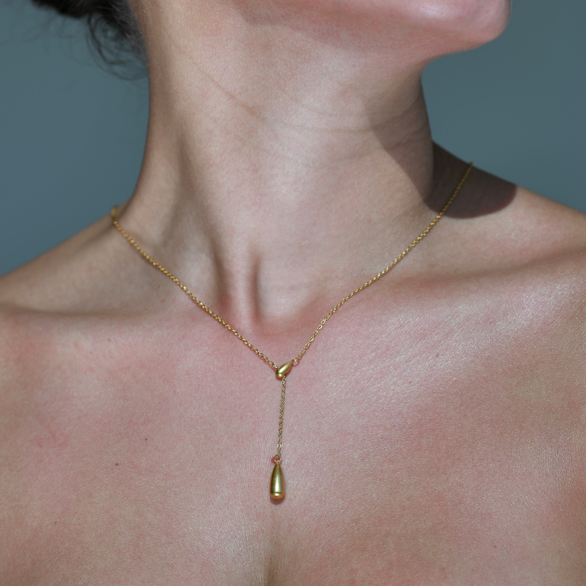 Elegant Slim Gold Chain with a Waterdrop pendant who is movable making the chain like a choker or longer necklace by reducing the drop distance of it. The water drop is attached on a smaller diagonal waterdrop which has a hole in the middle of it where the chain is versatile becoming longer or shorter.