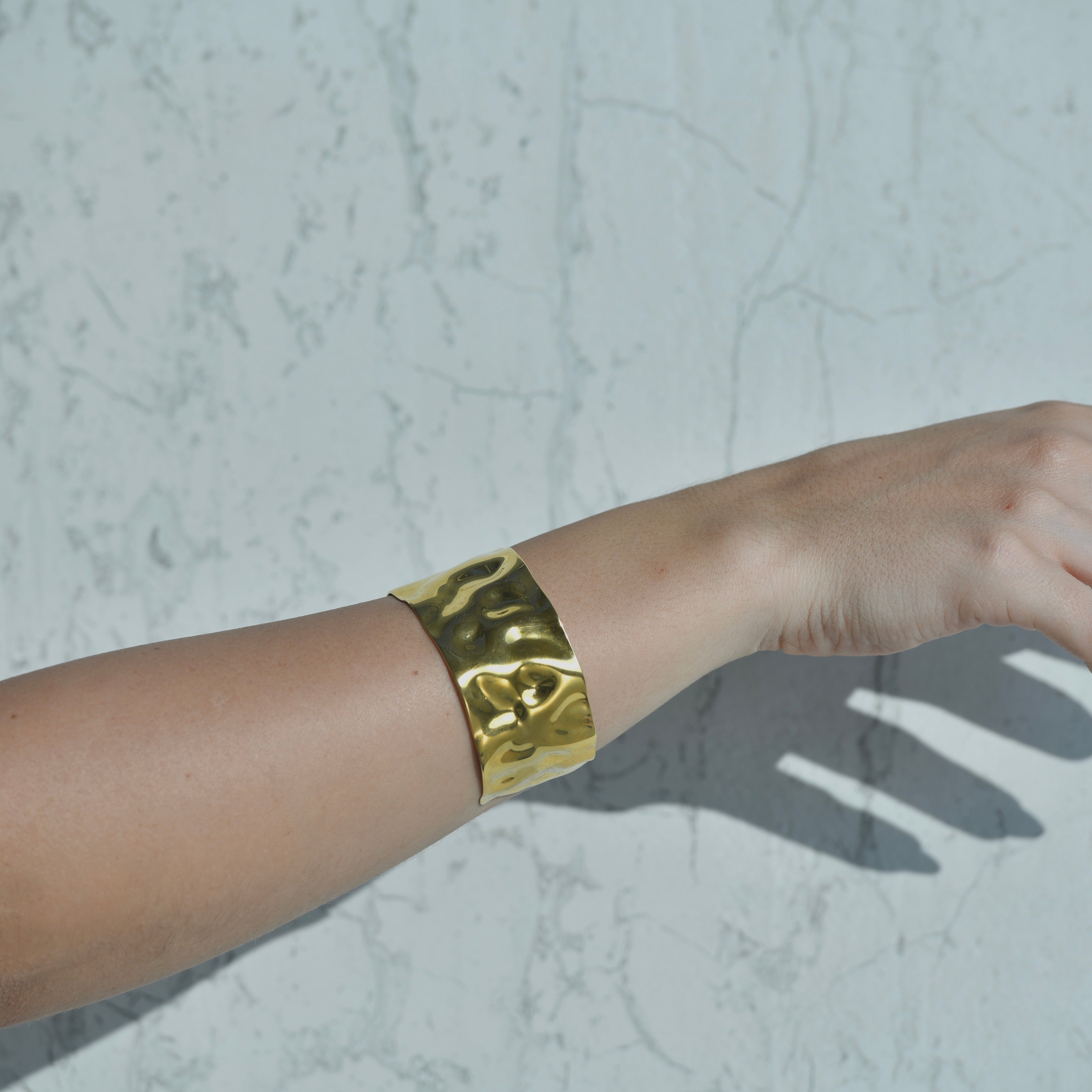 Wave gold cuff bracelet. Gold hammered irregular shiny surface of the gold cuff bracelet. Adjustable opening.